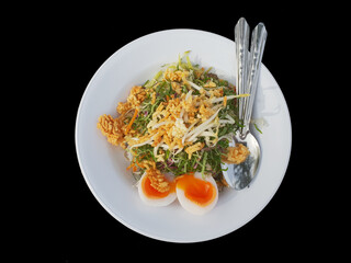 Khao Yum Rice with mixed herb vegetables Thai local southern style dish alongwith boiled eggs ready to eat isolated on black background
