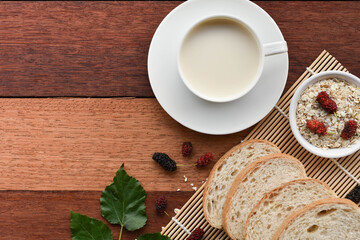 Milk and bread on wooden table in breakfast concept