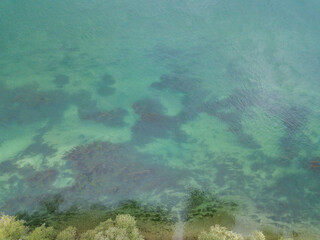 Aerial view of shallow water with sea floor visible from above. Clear water with impressive surface.