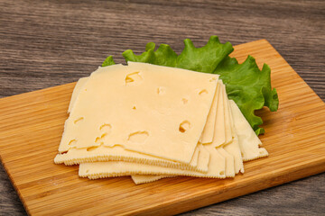 Sliced yellow cheese over board