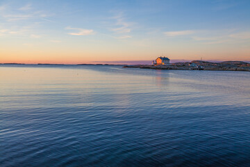 A beautiful sunset over the sea and an old house far away on the Swedish west coast, Sweden