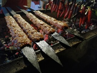 Cooking Adana kebabs on the restaurant style grill