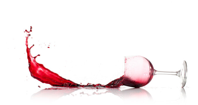 Red Wine Glass dropped and spilling over a white background
