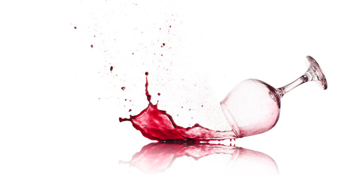 Red Wine Glass dropped and spilling over a white background

