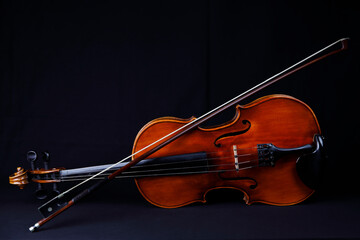 Eine Violine mit Violinbogen auf schwarzem Grund