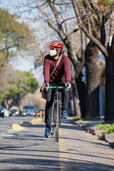 Cyclist on a trail bike with a mask on a sunny day.