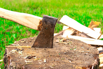 The wood chopper sticks out in wooden hemp. Ax and ax handle. Man's , male hands in white colors gloves holding an axe.