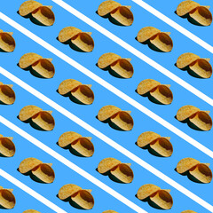 Pattern of light brown potato chips on a light blue background with white stripes
