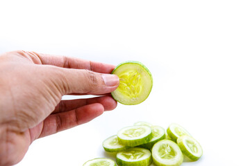 cucumber slices are held by the left hand. isolated white background. copyspace