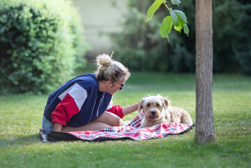 Girl with dog sitting on grass in park