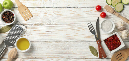 Composition with kitchen cutlery and ingredients for cooking on white wooden background, top view