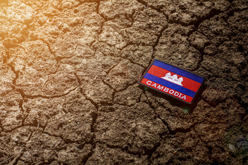 Cambodia flag on abandoned cracked ground.