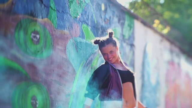 Beautiful Young Girl spraying colorful aerosol spray in the air at hot summer day. Daring creativity. Freedom, lifestyle, culture concept. Creative art. Talented female hipster student drawing picture