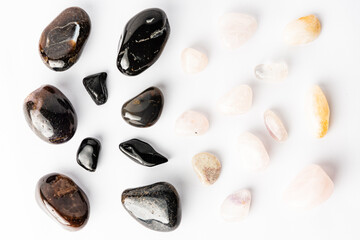 White and black semi-precious stones arranged neatly on a white background