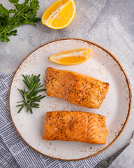 Delicious cooked salmon with lemon on a plate. Top view. Closeup
