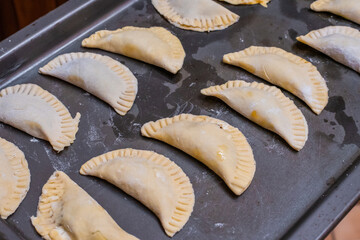 Delicious chiverre empanadas on a baking pan ready to go to the oven. Typical Hispanic holy week meal.