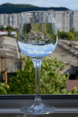 Glass of water with sky reflection