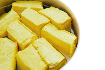 the yellow tofu in a basket filled with water. isolated white background. copyspace