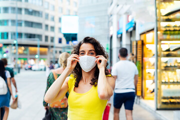 woman putting on a protective mask on the street