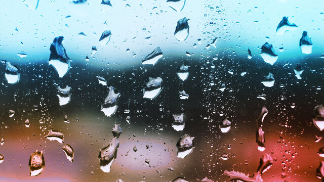 Raindrops on the window with warm lighting