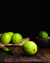 Fresh, raw and organic green lemon in focus with other lemons in composition