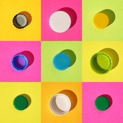 Colorful pattern: nine different multi-colored bottle caps metal and plastic on rainbow background, flat lay, hard shadow, square frame.