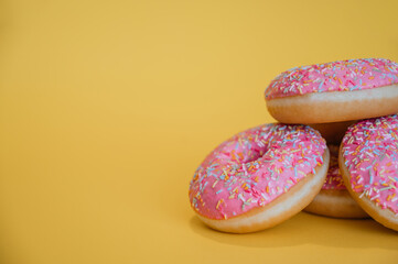 Pink donuts on yellow background and copy space