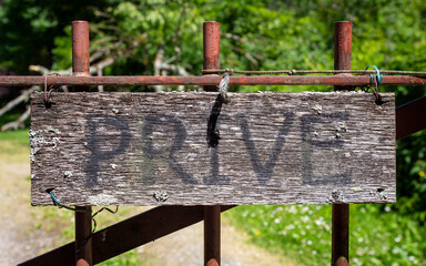 Privacy concept: Old wooden privé sign on a iron gate.