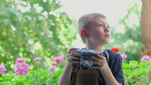 young boy is taking a picture with an old camera