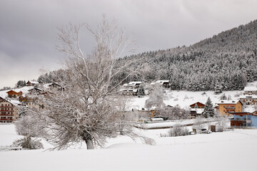 Fototapeta na wymiar Great tourist spot. Winter landscape with a forest and a small town.