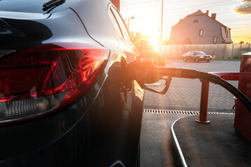 Naklejka premium Refueling car. Pump gas at petrol fuel station. Gasoline oil nozzle tank from hand person. Automotive industry or transportation concept.