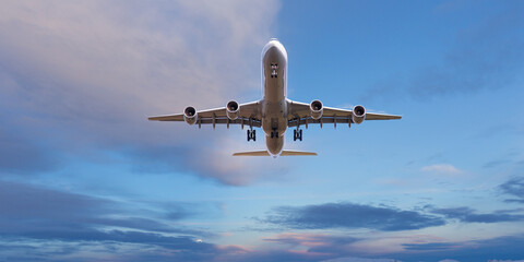 Huge two-storey passengers commercial airplane flying above dramatic clouds, sunset. Travel and business concept.