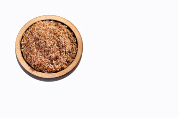 Crushed flax seeds in the wooden bowl - Linum usitatissimum