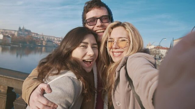 Portrait of diverse friends enjoying their mood. Attractive man, asian girl, and natural blonde young woman smiling at the camera. Cheerful guys feeling happy together. Concept of friendship.