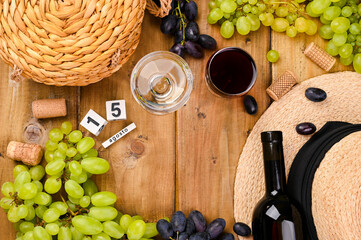  Traditional Italian holiday and summer holidays, August 15 on a cube calendar. Ferragosto harvest festival. Red and white wine on a wooden background and grapes. Copy space. Flat lay.