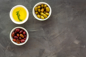 Olive oil in bowl near oilves from above copy space