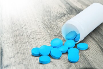 Medical colored pills in the plastic bottle on the desk