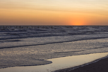 Sunset with rough sea on the beach
