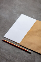 paper sheet and pencil on gray background