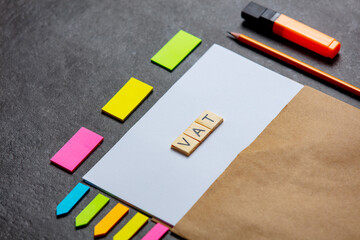 VAT letters on paper sheet and notes around on a table