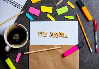 My book letters on paper sheet and notes around with cup of coffee on a table