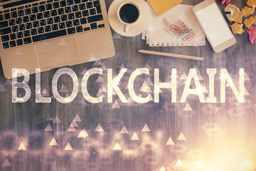 Blockchain theme hologram drawings over computer on the desktop background. Top view. Double...
