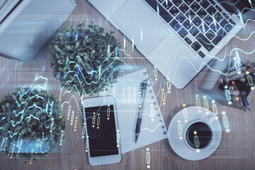 Multi exposure of financial chart hologram over desktop with phone. Top view. Mobile trade platform...