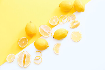 Flat lay composition with ripe juicy lemons on white and yellow background