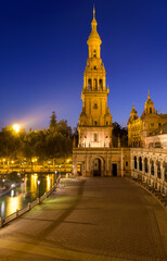 Fototapeta na wymiar North Tower - A dusk view of illuminated north tower of Spanish Square - Plaza de España, on a clear Autumn evening. Seville. Andalusia, Spain.