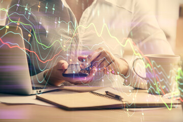 Double exposure of forex chart sketch hologram and woman holding and using a mobile device. Financial market concept.