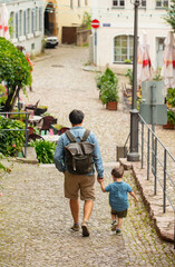 Fototapeta na wymiar Father and son walk along the street of the old city in Europe, Germany