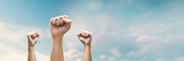 Man hands with clenched fist on sky background expressing freedom