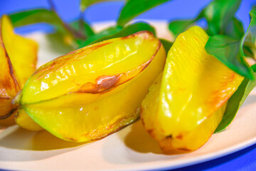 carambola fruits served on plate on blue background
