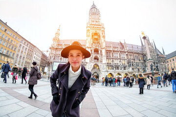 Young Woman Tourists selfie with mobile phone near the  Marienplatz town hall and Frauenkirche in Munich, Germany